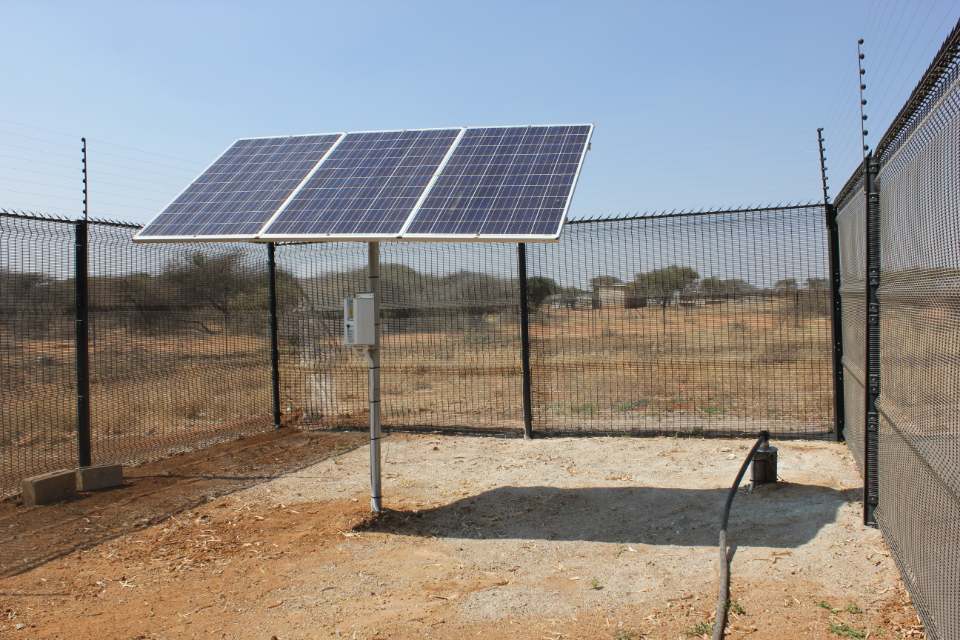 Solar panels beside a water tank in Mochudi, Botswana, photographed in 2018